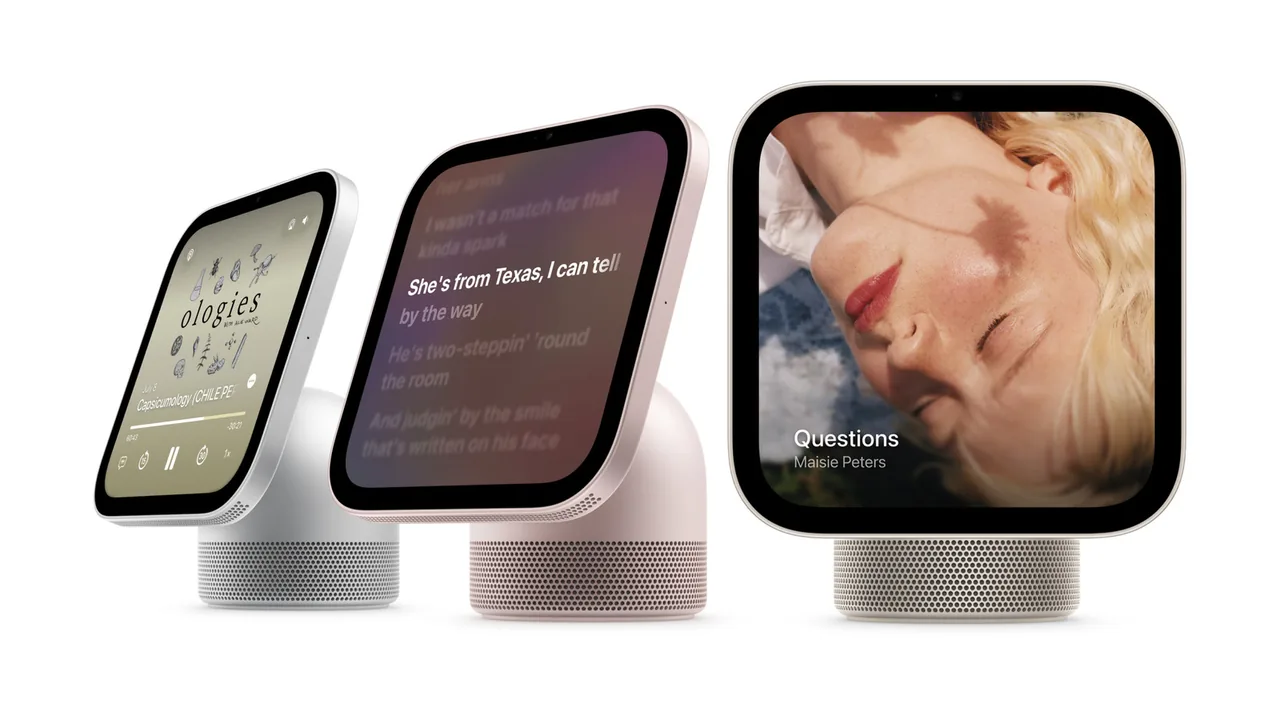 Three rounded-square smart displays on perforated speaker bases against a white background. Their screens show podcast playback controls, song lyrics, and cover art labeled “Questions” by Maisie Peters.
