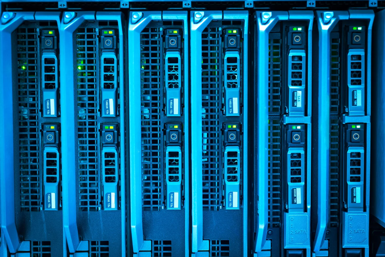 Blue-lit server racks with rows of storage drives and green indicator lights.