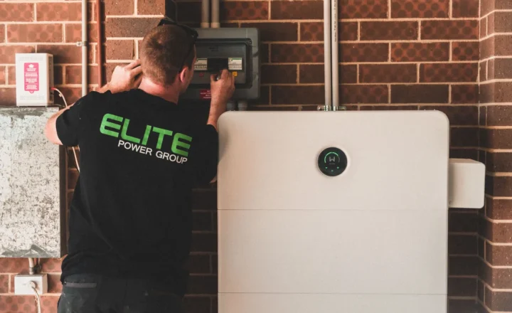 Electrician installing a home energy battery storage unit. Renewable and sustainable energy solution for residential use.