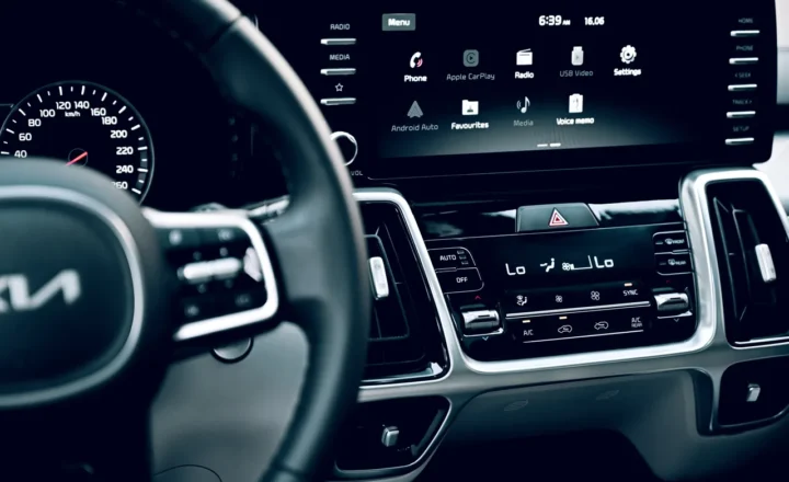 A Kia dashboard touchscreen showing phone, Apple CarPlay, radio and settings icons.